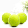 A set of six neon yellow tennis balls resting on a white surface with bright bokeh background.