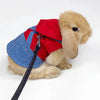 Un jouet de lapin moelleux portant un gilet en denim et un col rouge.