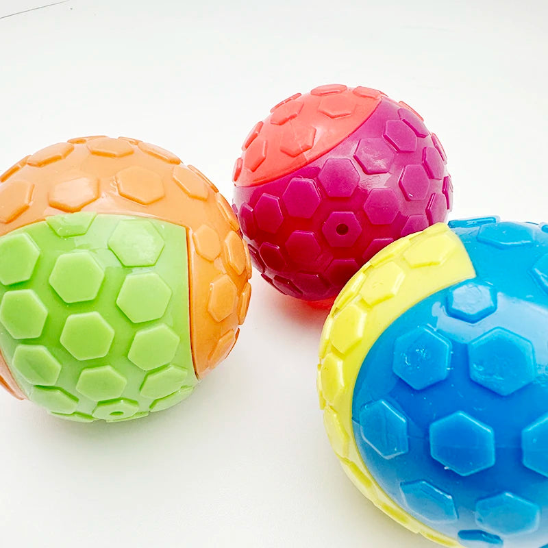 Three brightly colored squeaky rubber play balls for dogs in orange, pink, and blue.