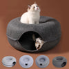 A fluffy white cat is sitting inside a gray donut-shaped cat bed with an entrance, shown alongside various sizes of the produ