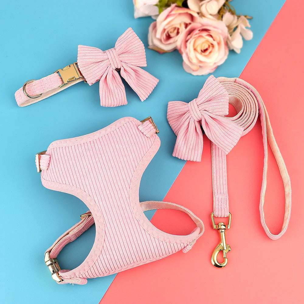 Pinkes gestricktes Hundehalsband und Leine-Set mit dekorativen Schleifen vor blauem und rosa Hintergrund.