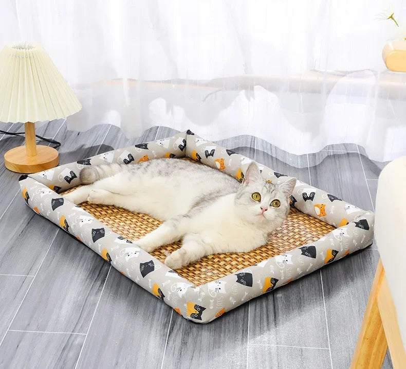 A white cat is relaxing in a rectangular rattan pet bed with a breathable cotton mat on a gray floor.
