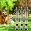 Three stainless steel adjustable ultrasonic dog training whistles displayed outdoors on green grass with dogs in the backgrou