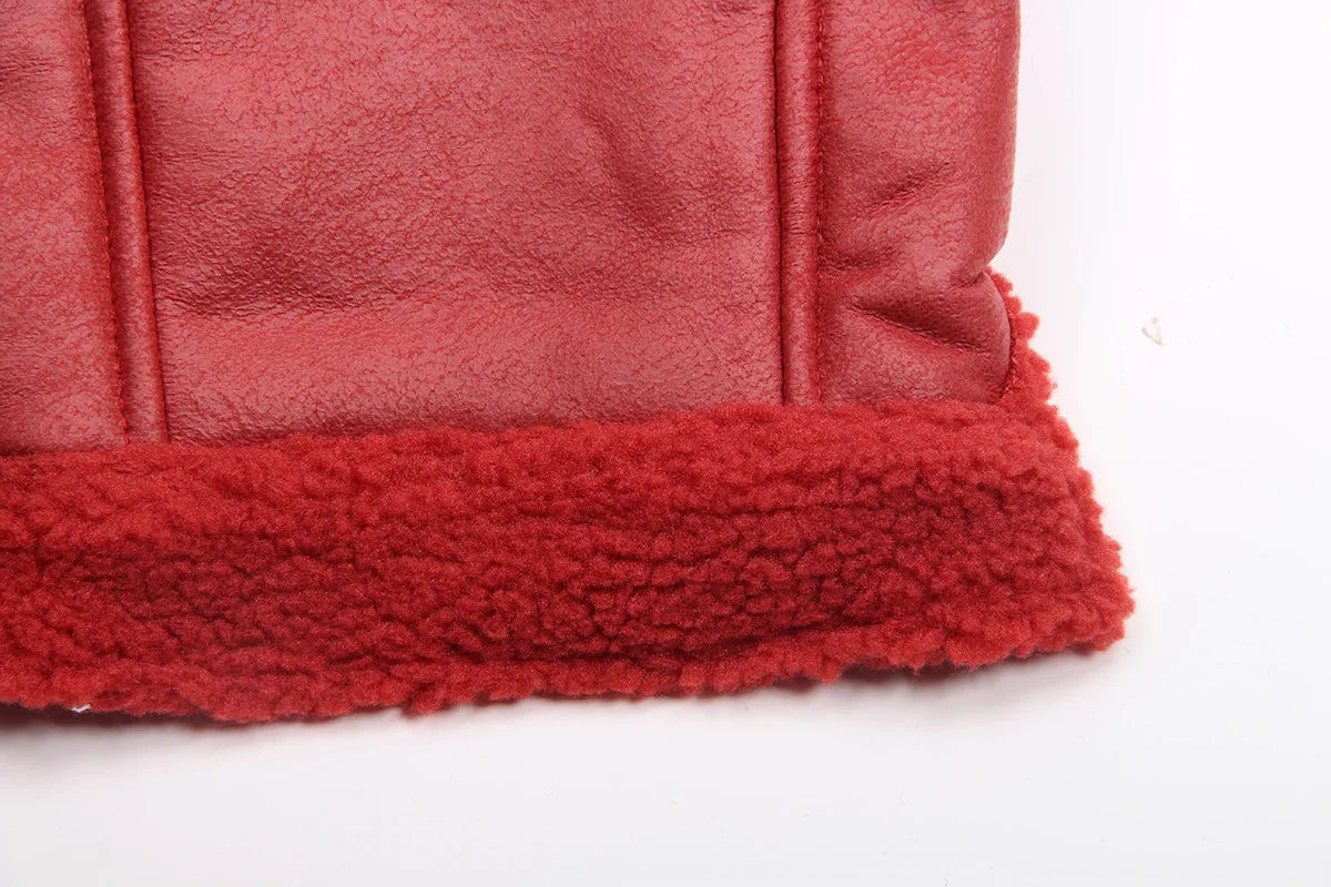 A close-up of a red faux leather dog coat with a thick, fuzzy red fleece lining.