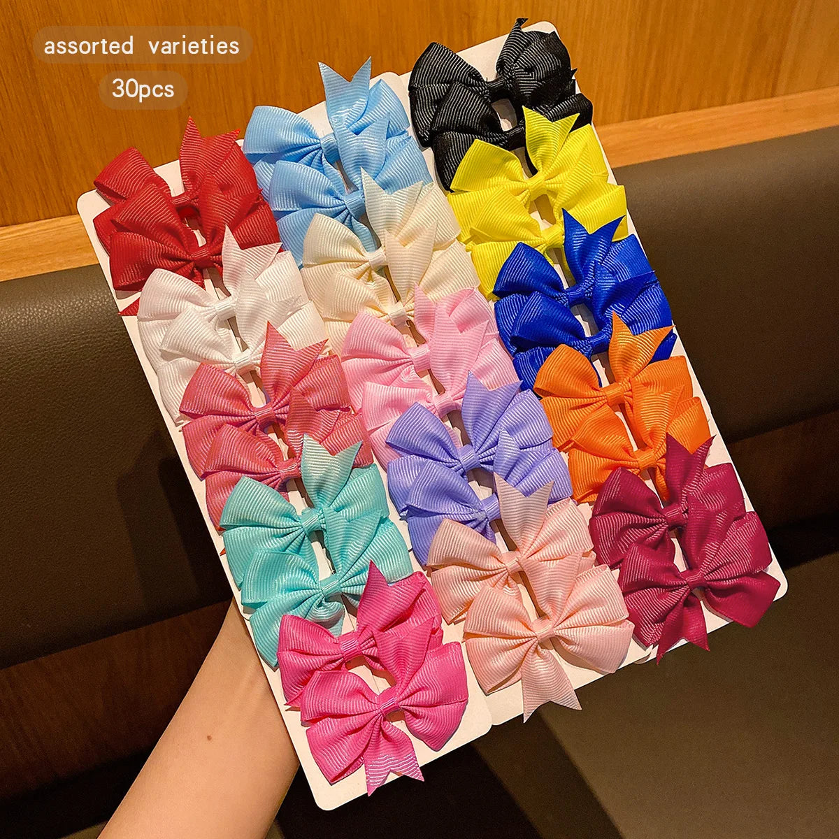 Assorted varieties of colorful fabric hair clips in various shades including red, blue, yellow, and pink
