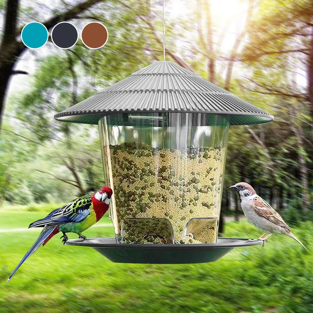 A window-mounted bird feeder with a conical roof and clear viewing panel filled with seeds, suspended outdoors.