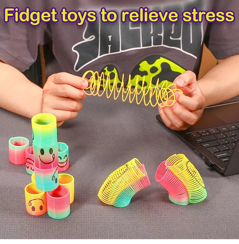 Hands are holding and manipulating colorful spring coil fidget toys for stress relief.
