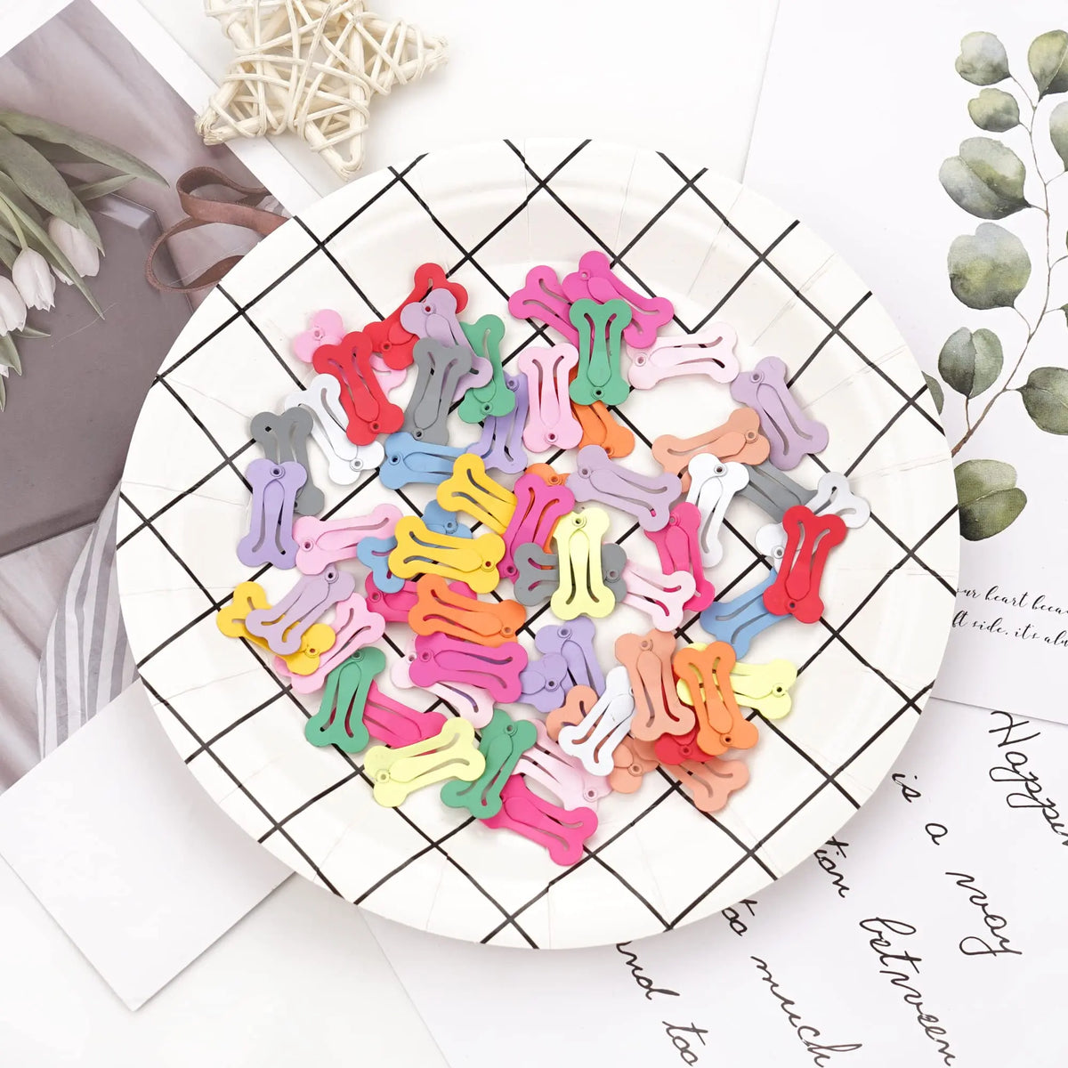 A plate filled with multi-colored dog hair clips for pet grooming, arranged in various shades of pink, purple, green, and yel