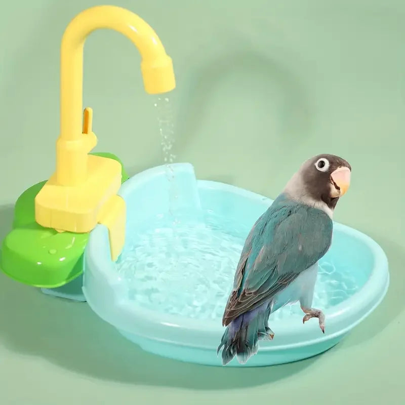 A yellow automatic parrot shower is dispensing water into a light blue bird bath basin where a dove is bathing.