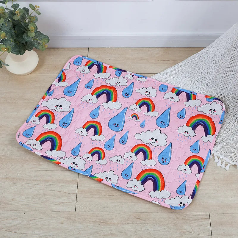 Pink washable pet training mat featuring colorful rainbows and clouds for dogs
