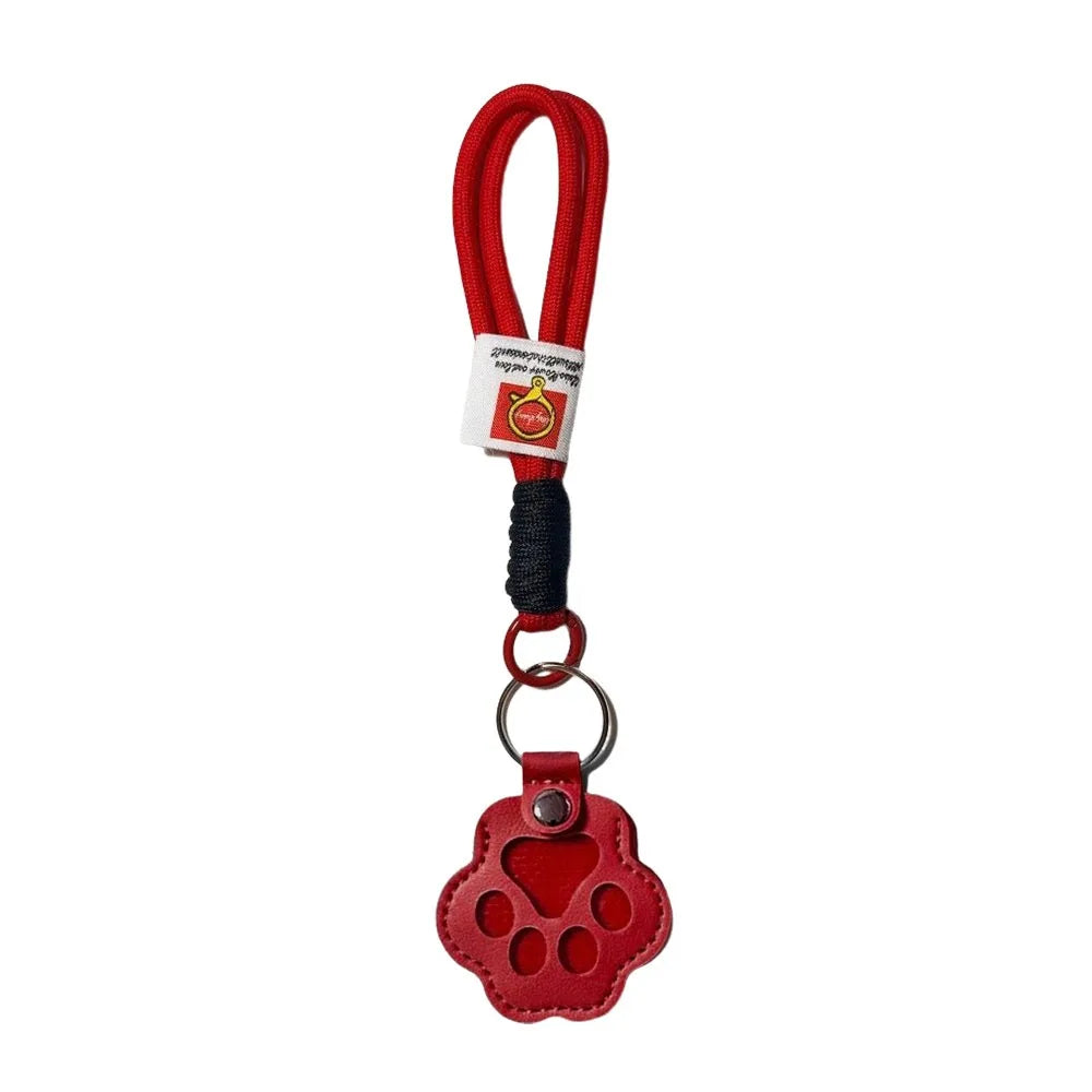 Red refillable pet hair keychain with a cat paw charm and black cord.