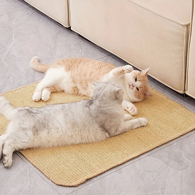 Two cats are relaxing on a woven sisal scratching mat indoors.