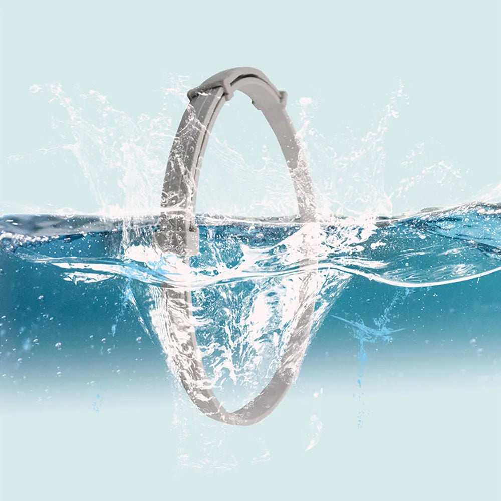 A silver adjustable waterproof pet collar is shown splashing water in a clear blue environment.