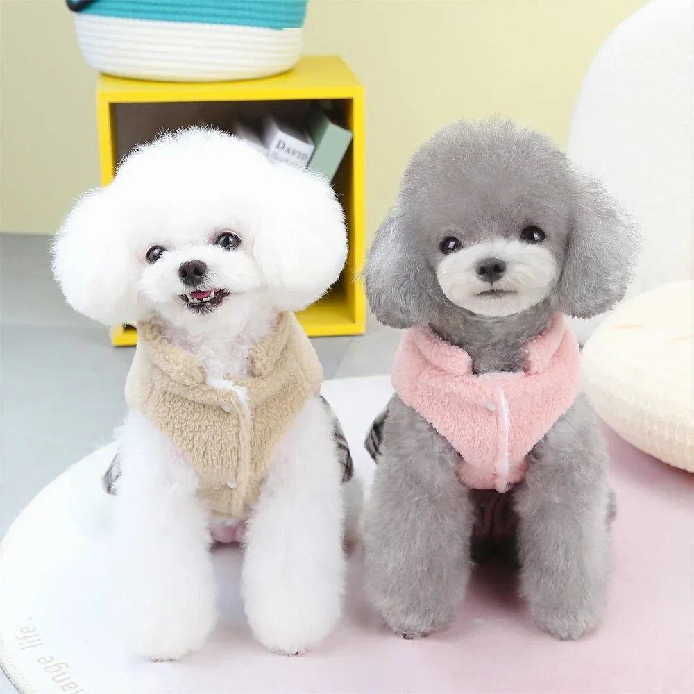 Two small poodle-like plush toys, one white and one gray, wearing pink and beige knitted dresses.