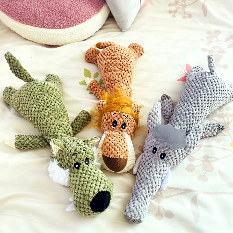 Collection de jouets en peluche pour chiens tricotés à la main dans des tons terreux comme le vert, l'orange et le gris.