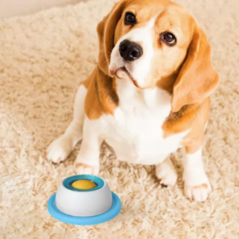 A beagle puppy looks at an interactive dog slow feeder lick mat on a beige surface.