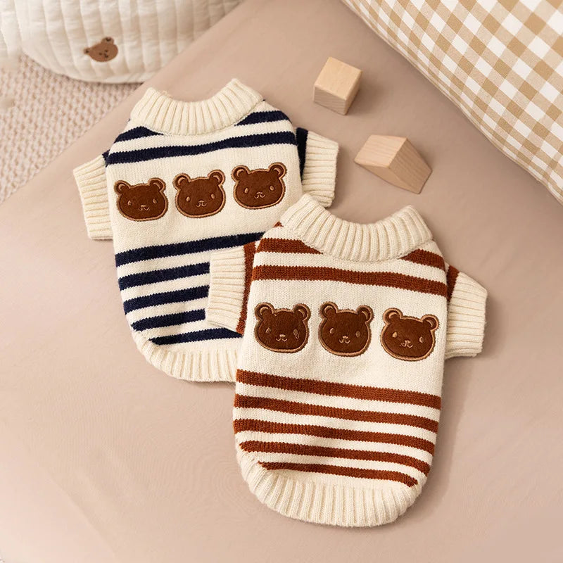 A knitted striped bear cardigan pet sweater for small dogs and cats resting on a beige fabric.