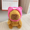Flauschiges braunes Capybara-Plüschtier mit rosa Hoodie und kleinen Flügeln.