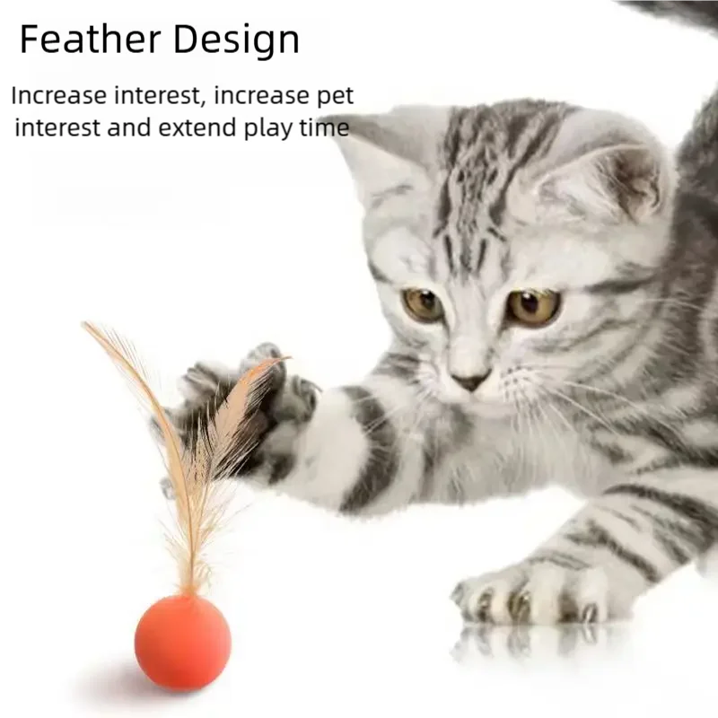 A kitten plays with a feather toy attached to an orange elastic ball.