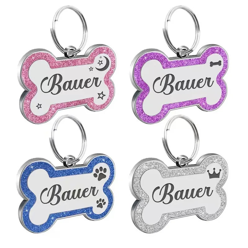 Silver and pink paw print shaped pet ID tags with the name Bauer engraved on them