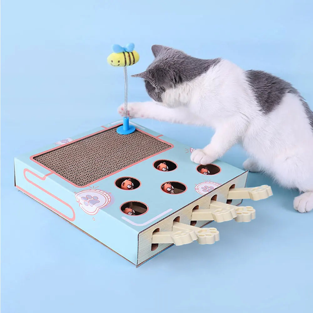 A gray and white cat is interacting with an interactive whack-a-mole style scratching board featuring small holes and a mole 
