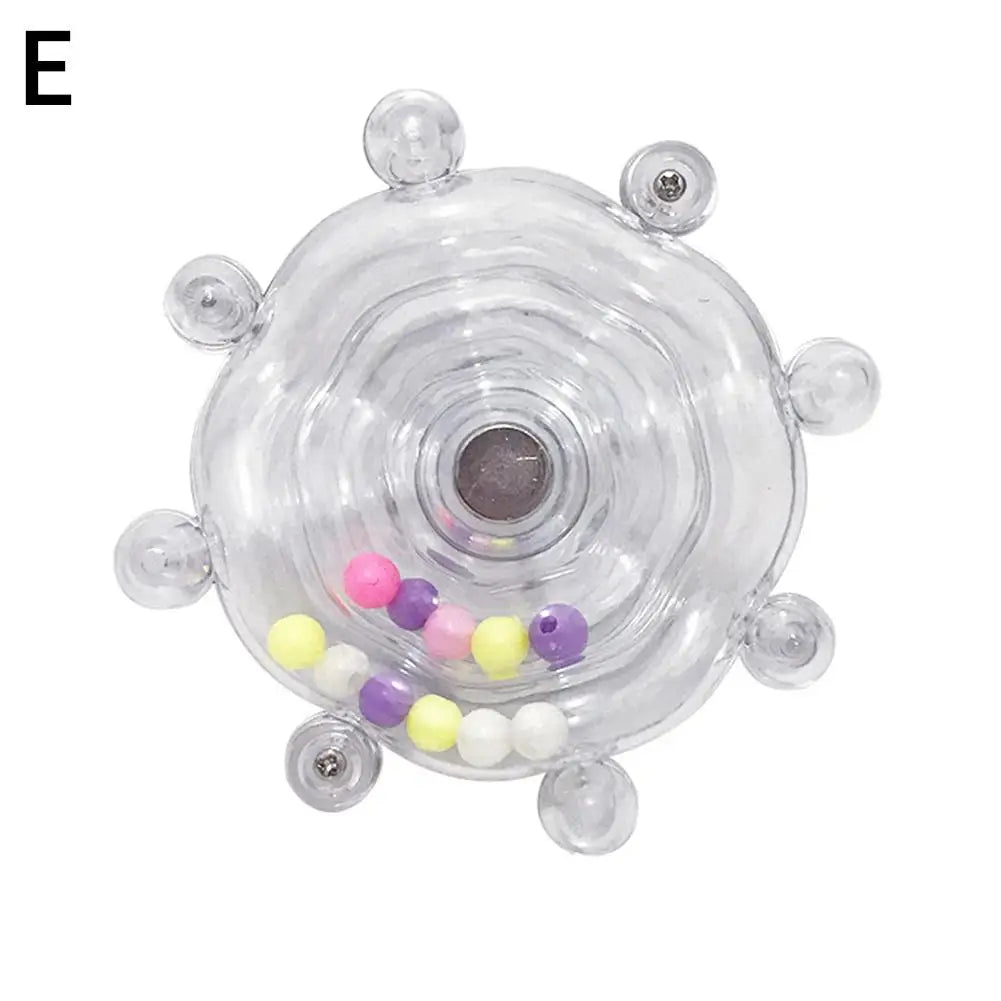 A clear rotating parrot treat dispenser with various colored treats visible around the perimeter.