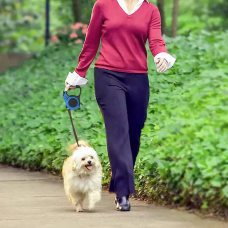 A woman is walking a small, fluffy white dog on a leash outdoors.