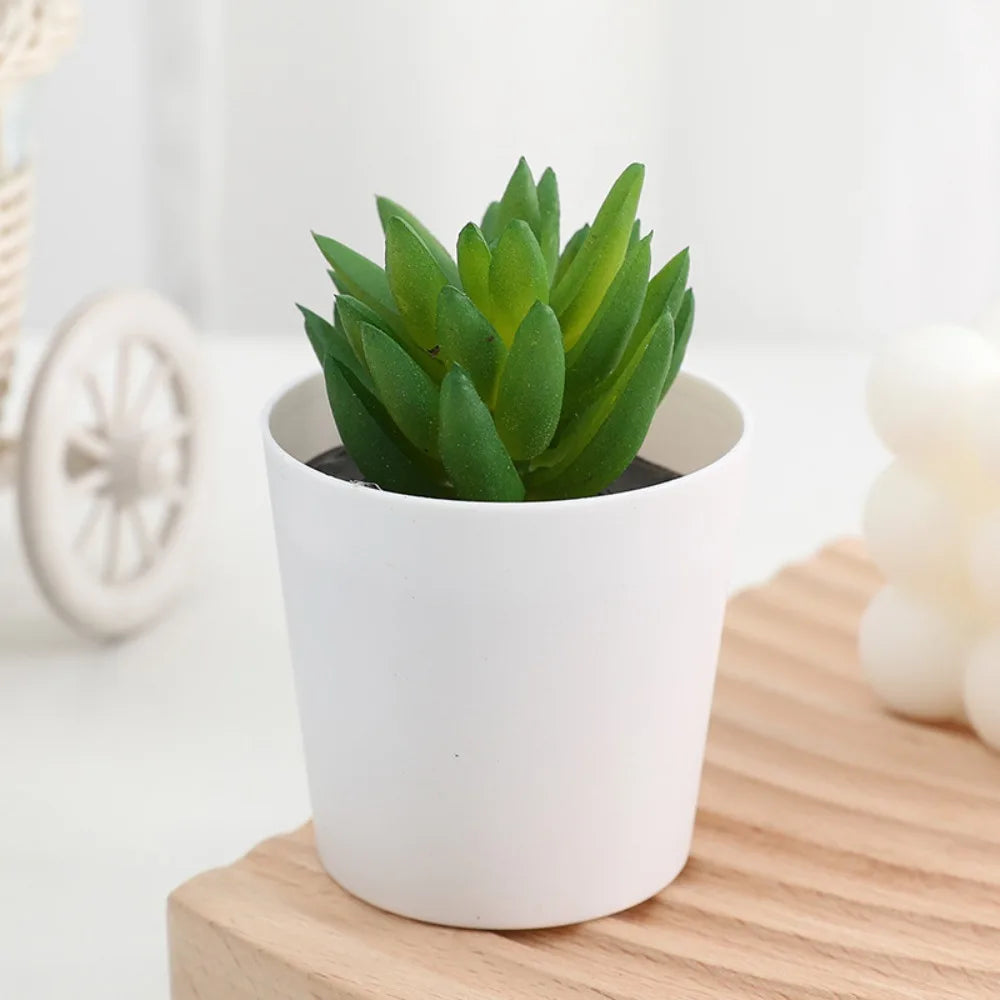 A vibrant green artificial cactus succulent bonsai plant in a white ceramic pot sitting on a wooden surface.
