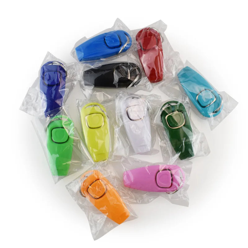 A collection of colorful dog training clickers and whistles in various shades packaged in clear plastic bags.