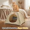 A fluffy orange cat sits inside a beige pyramid structure pet tent bed on a wooden floor.