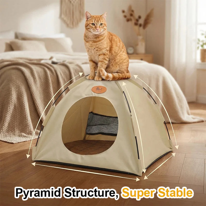 A fluffy orange cat sits inside a beige pyramid structure pet tent bed on a wooden floor.