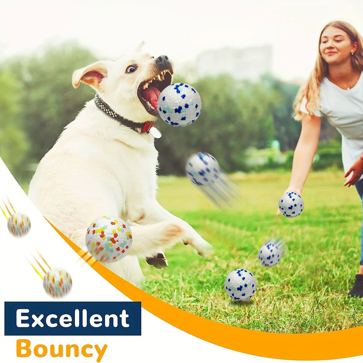 A happy dog is playing with blue and white bouncy balls in a grassy outdoor setting.