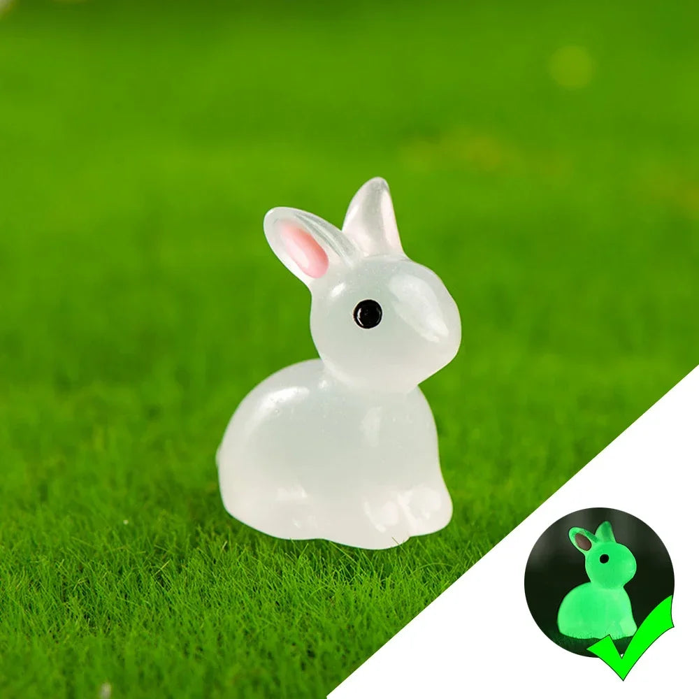 A white resin bunny figurine glowing in the green grass.