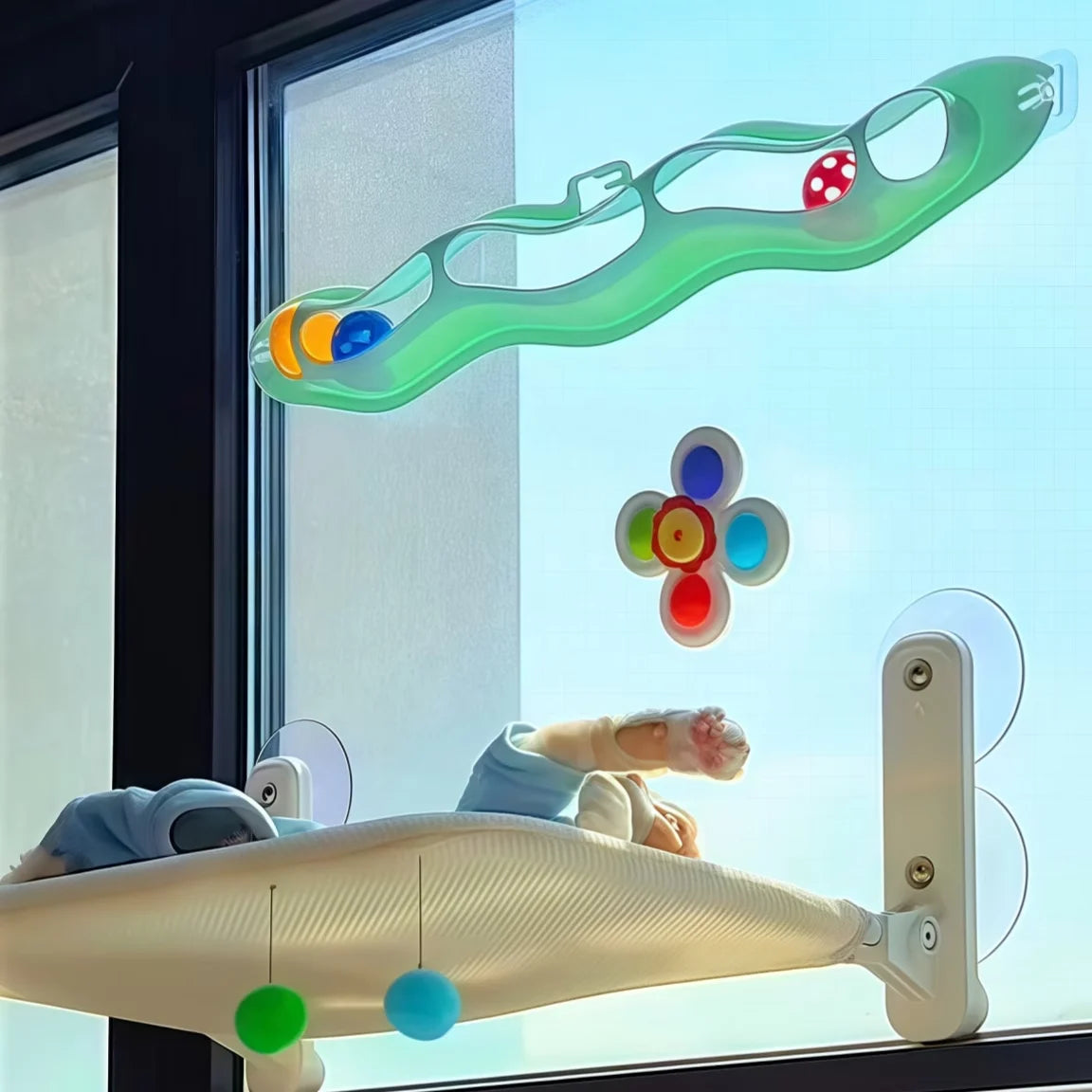 Un ensemble de jouets pour bain de chat en plastique vert avec des boules colorées, exposé dans une vitrine à côté d'un plate