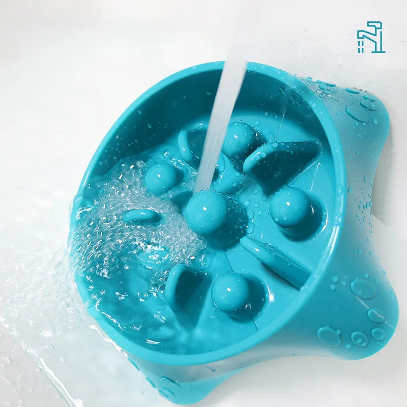 A bright blue slow feeder dog bowl is shown being filled with water.