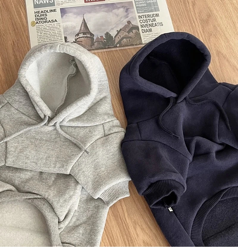 Gros plan d'un pull en polaire gris et d'une version bleu marine foncé, posés sur une surface en bois.