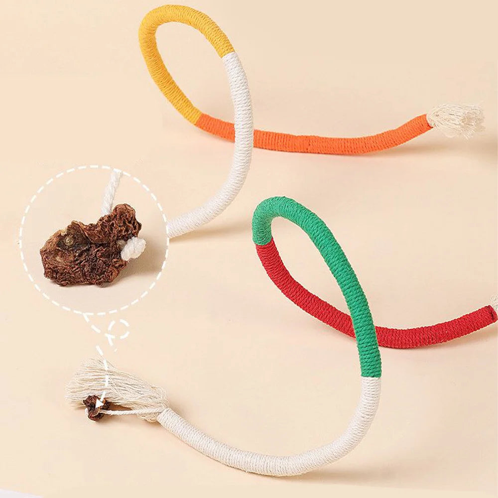 A collection of colorful cotton rope cat toys, including orange, white, and green, with silvervine fruit attached.