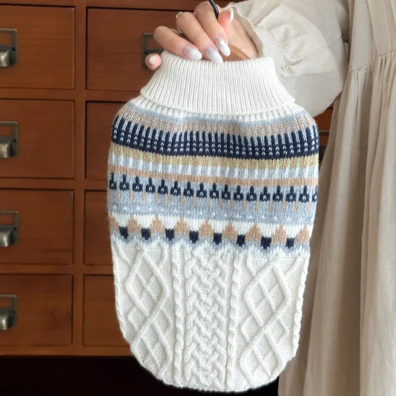A close-up of a cozy knit pet sweater for dogs and cats featuring striped patterns in beige, blue, and white.