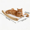 An orange tabby cat is relaxing on a beige wall-mounted hammock and climbing shelf.