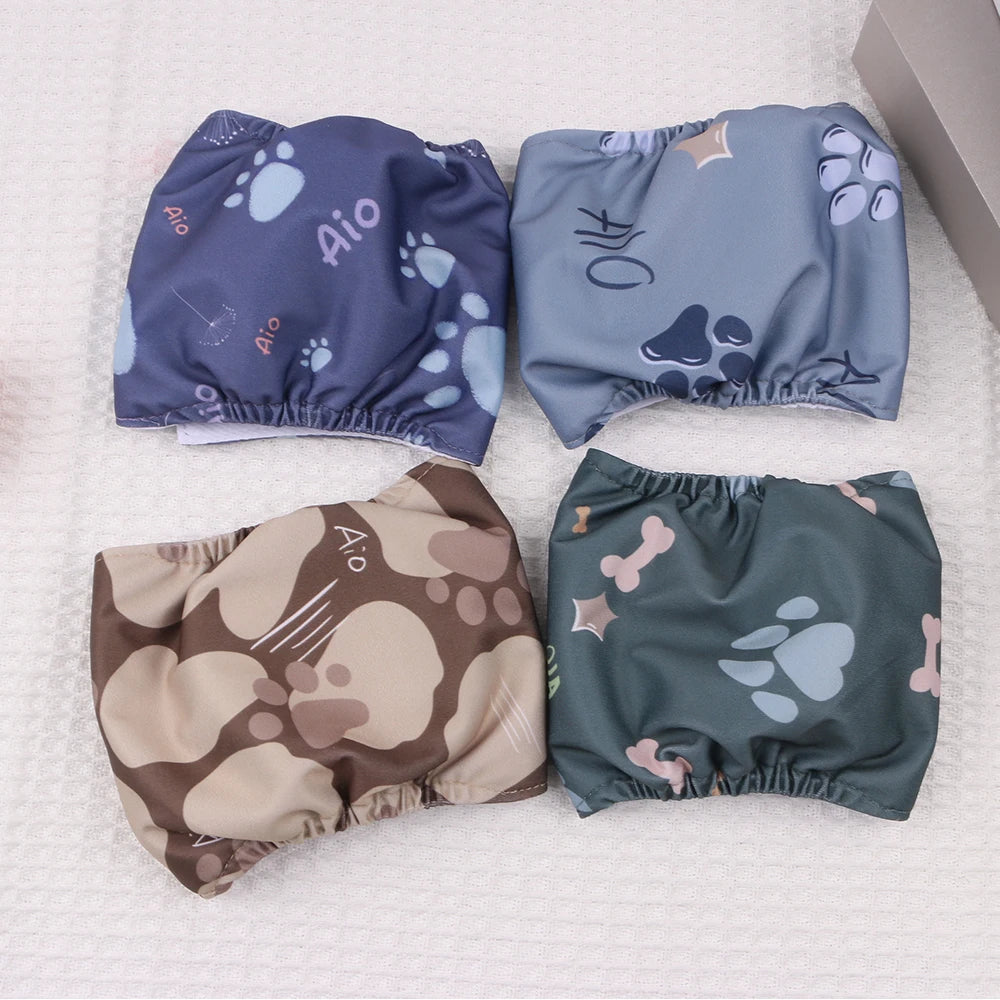 Four reusable dog belly bands in various shades of blue and green laid out on a white surface.