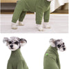 A fluffy grey dog wearing a olive green thermal fleece jumpsuit for winter warmth.