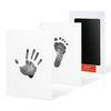 A set of black ink pet paw print and handprint cards displayed in a white frame.