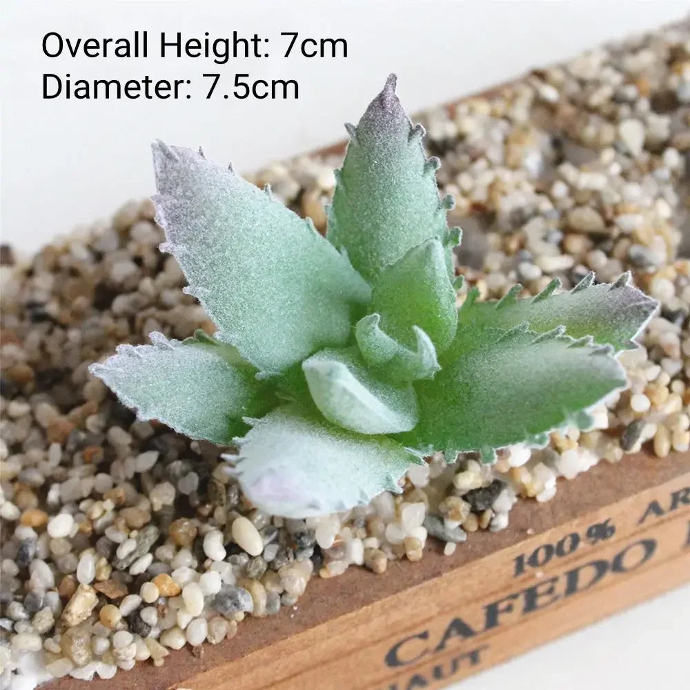 A small, flocked artificial succulent plant with green leaves is displayed on a bed of small pebbles.