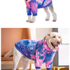 Un chien de couleur claire portant un sweat à capuche en polaire tie-dye rose et bleu.