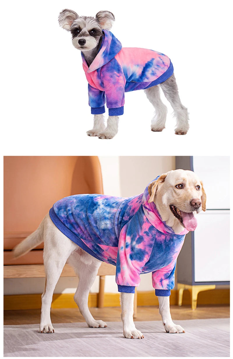 Un chien de couleur claire portant un sweat à capuche en polaire tie-dye rose et bleu.