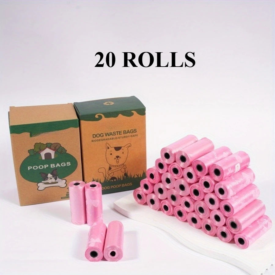 A pile of 20 rolls of pink puppy crown patterned dog waste bags is shown next to their cardboard packaging.