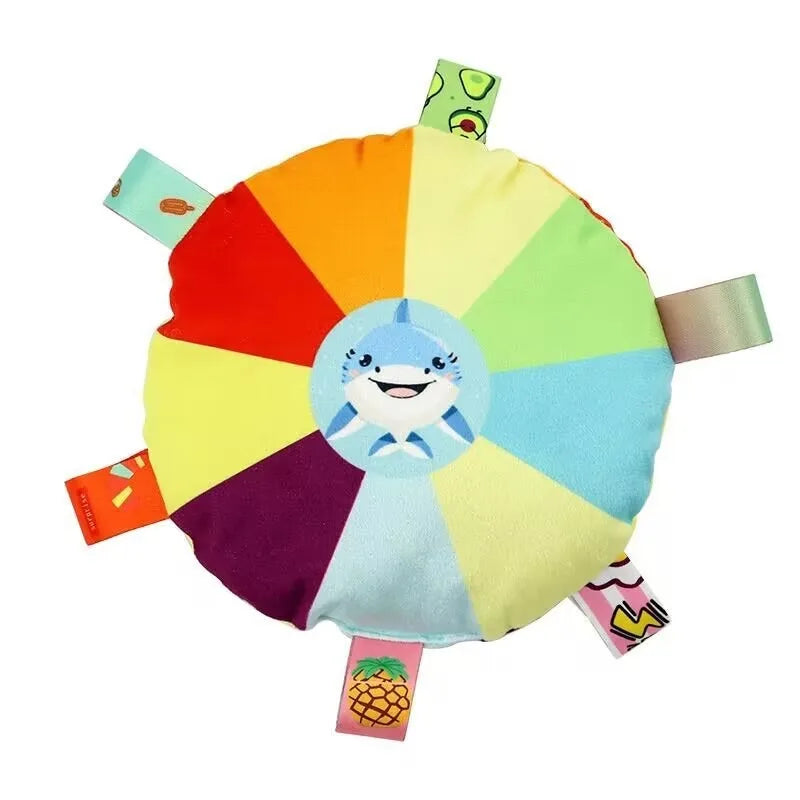 A colorful, round plush dog toy shaped like a flying disc with various colored segments and attached tags.