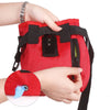 A hand is holding a red durable pet training treat bag with black straps and an attached red circular item.