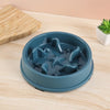 A blue anti-slip slow feeder bowl for small dogs and cats resting on a light wooden surface.