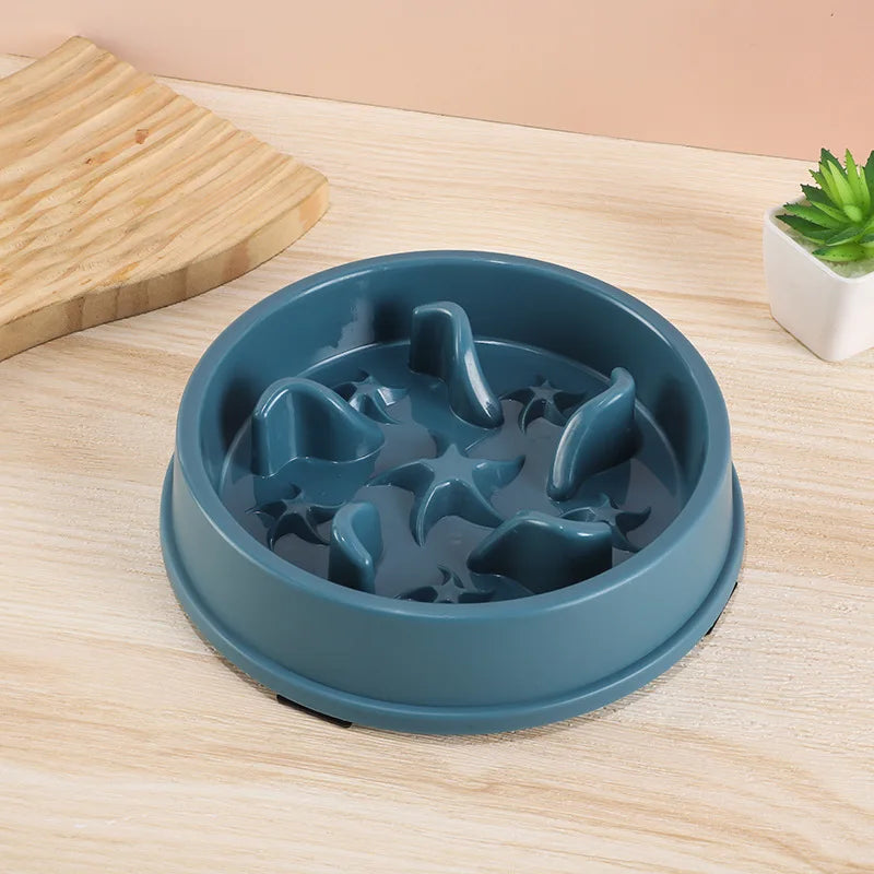 A blue anti-slip slow feeder bowl for small dogs and cats resting on a light wooden surface.